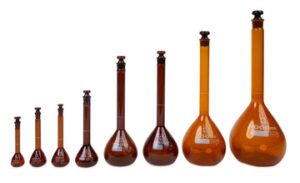 A set of amber glass volumetric flasks in various sizes.