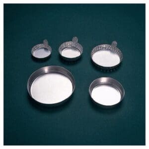 Measuring cups and bowls filled with white powders on a dark surface.